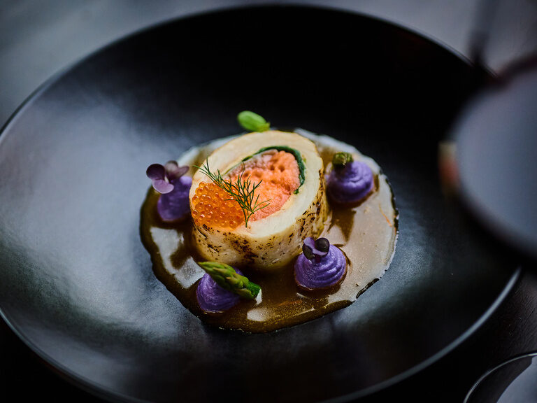 Gefüllte Fischrolle mit Lachs, Kaviar, Spargel und violetter Kartoffelcreme.
