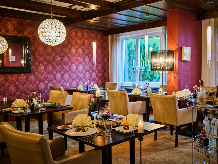 Elegantes Restaurant mit gedeckten Tischen, Kerzenlicht und stilvollem Ambiente.