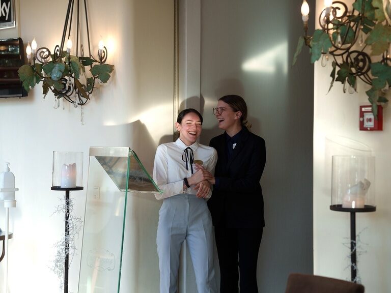 Zwei Mitarbeiterinnen des Hauses lachen herzlich an der Rezeption im Eingangsbereich.