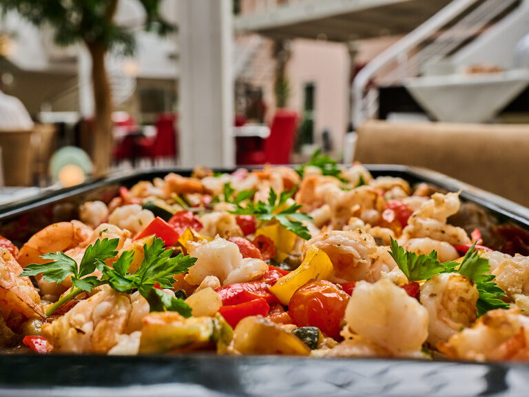 Bunte Garnelenpfanne mit Paprika und Kräutern in Buffetwanne.