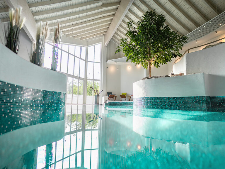 Heller Indoor-Pool mit Naturlicht und Pflanzen im Hotel Wutzschleife in Rötz.